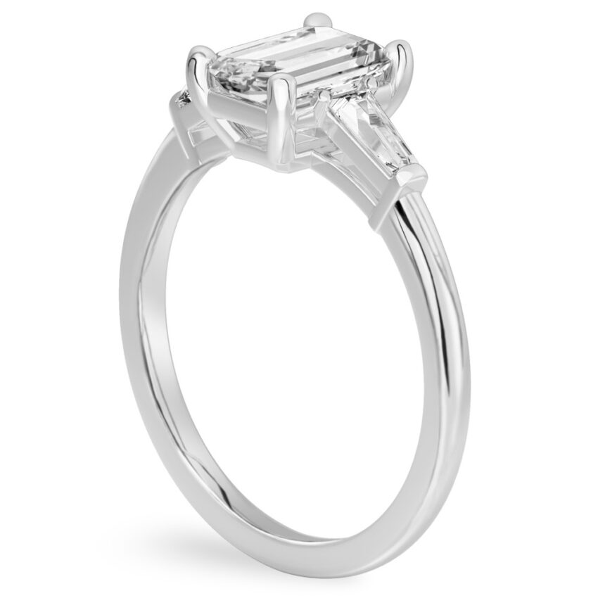 Angle view of emerald cut diamond tapered baguette engagement ring in palladium