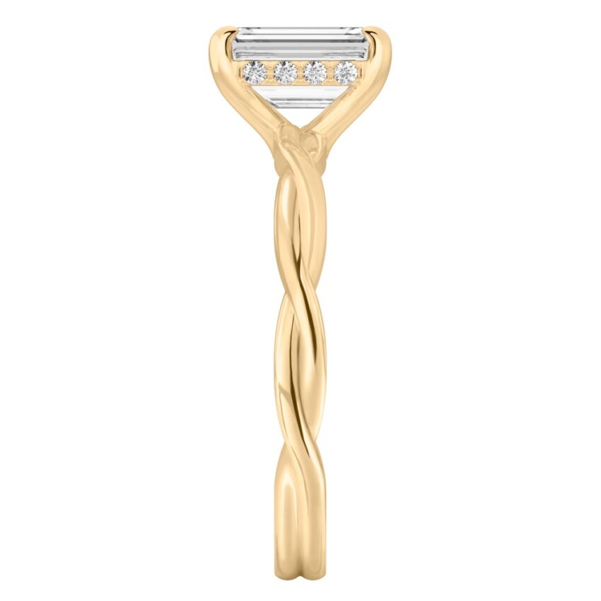 Side view of emerald cut diamond twisted hidden halo engagement ring in yellow gold
