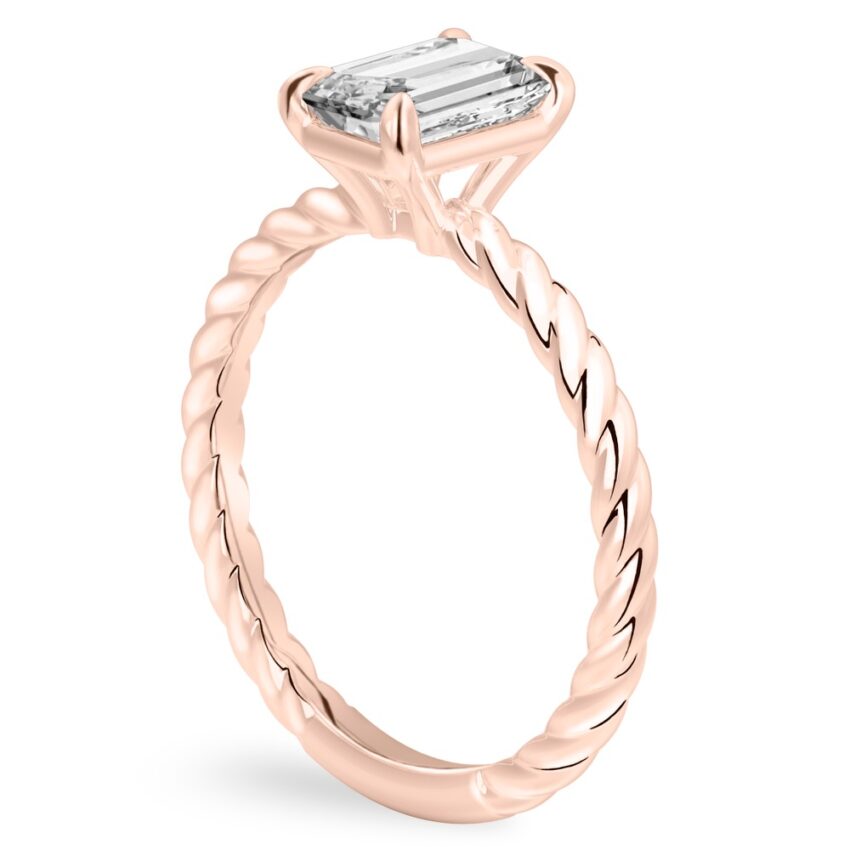 Angle view of emerald cut diamond twisted rope engagement ring in rose gold