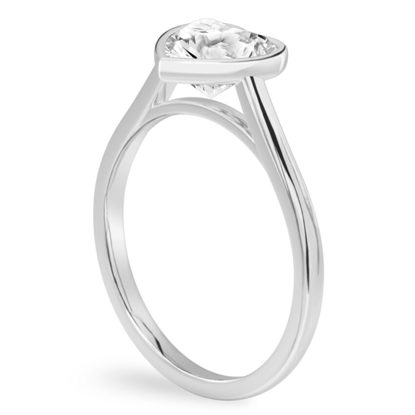 Angle view of heart shape diamond bezel engagement ring in white gold