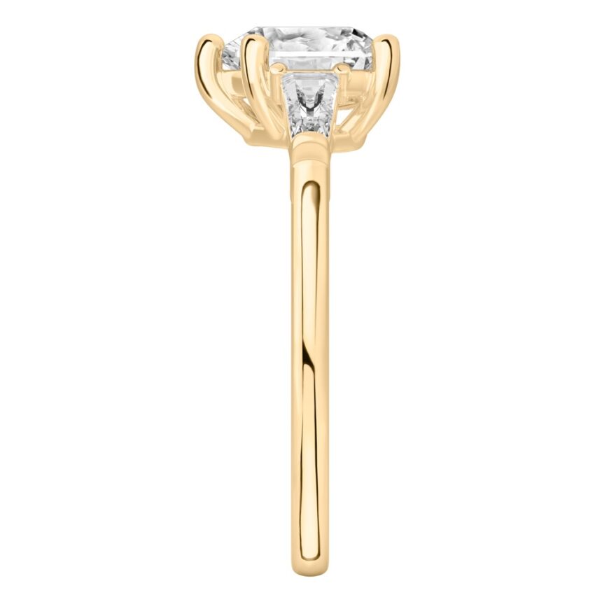 Side view of heart shape diamond tapered baguette engagement ring in yellow gold