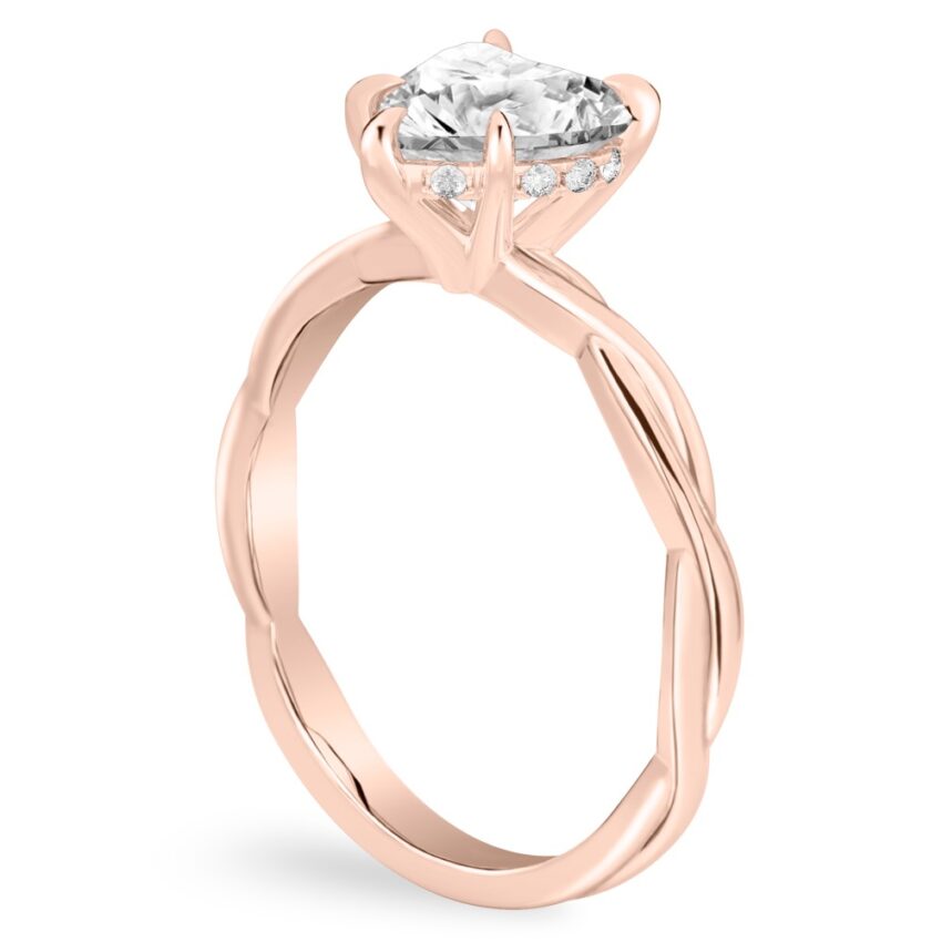 Angle view of heart shape diamond twisted hidden halo engagement ring in rose gold