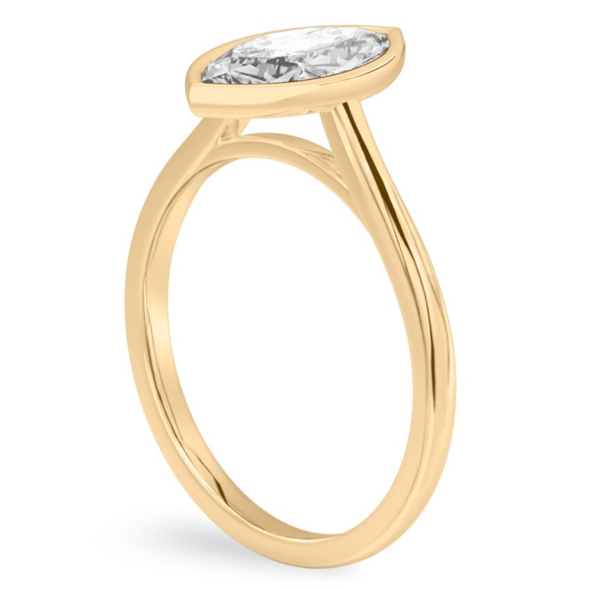 Angle view of marquise cut diamond bezel engagement ring in yellow gold