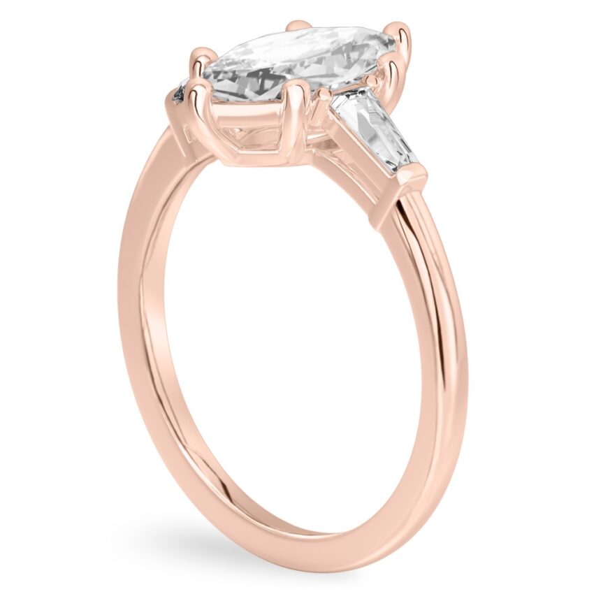 Angle view of marquise cut diamond tapered baguette engagement ring in rose gold