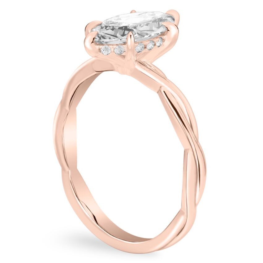 Angle view of marquise cut diamond twisted hidden halo engagement ring in rose gold
