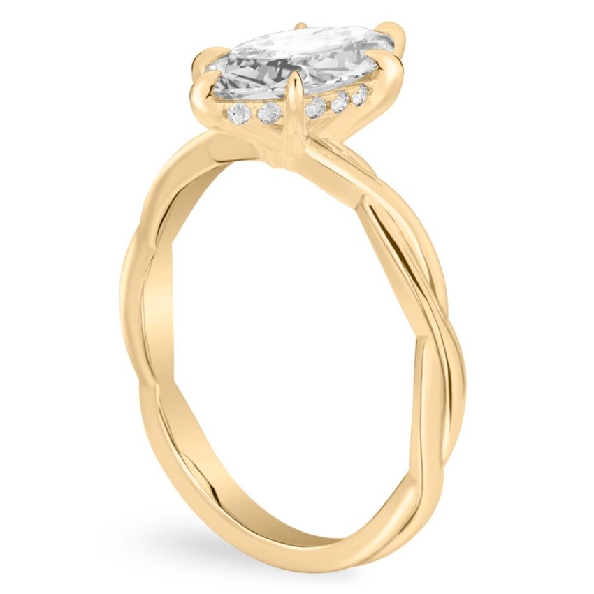 Angle view of marquise cut diamond twisted hidden halo engagement ring in yellow gold