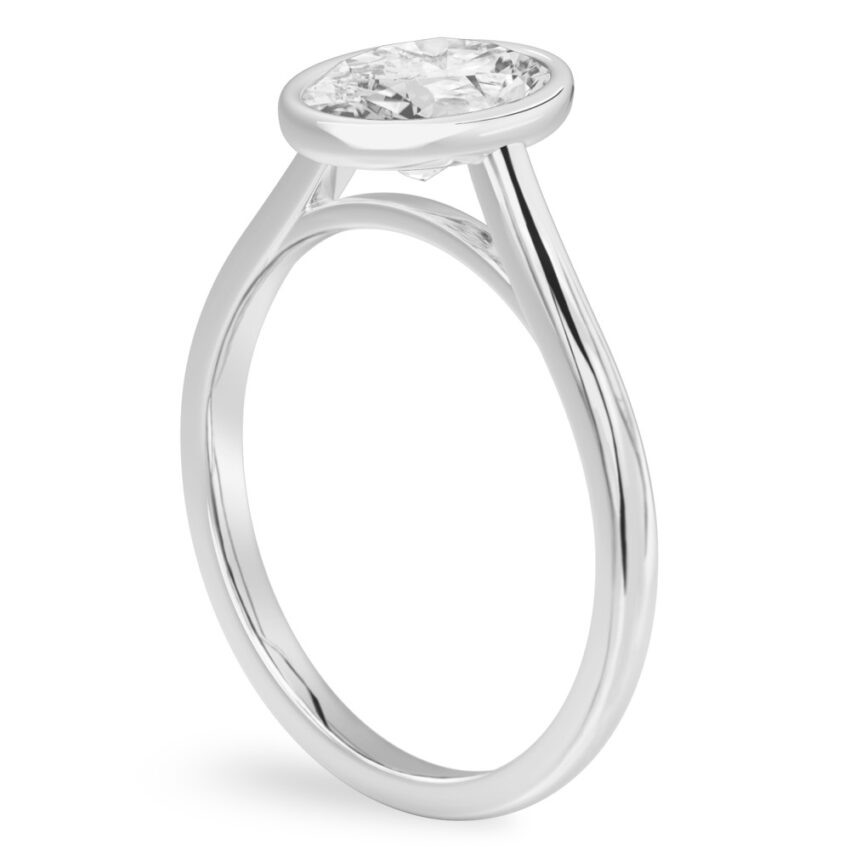 Angle view of oval shape diamond bezel engagement ring in white gold