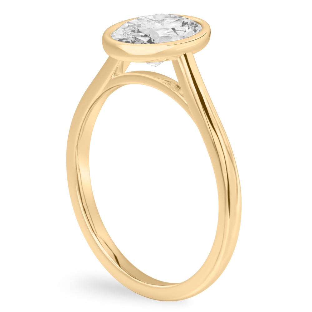 Angle view of oval shape diamond bezel engagement ring in yellow gold