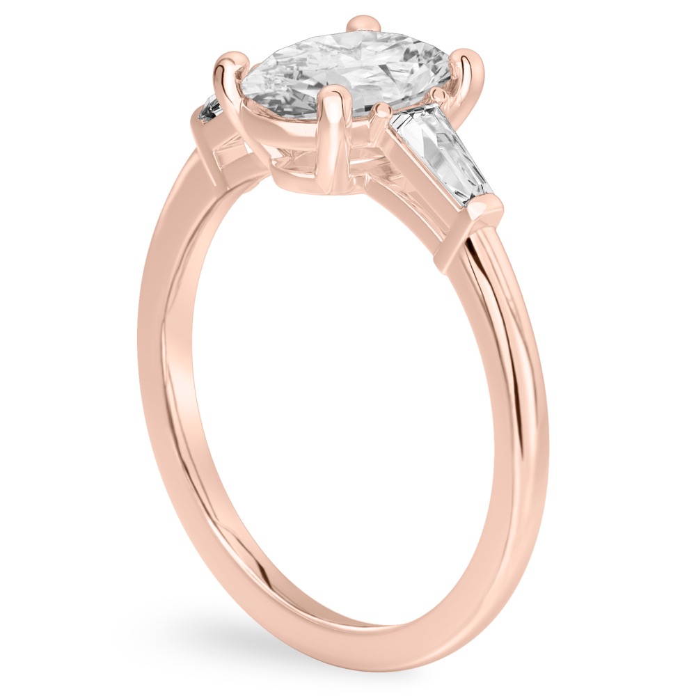 Angle view of oval shape diamond tapered baguette engagement ring in rose gold
