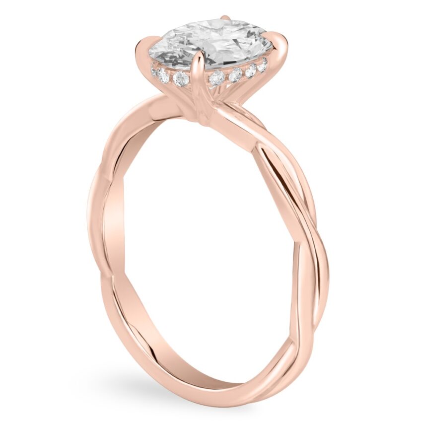 Angle view of oval shape diamond twisted hidden halo engagement ring in rose gold