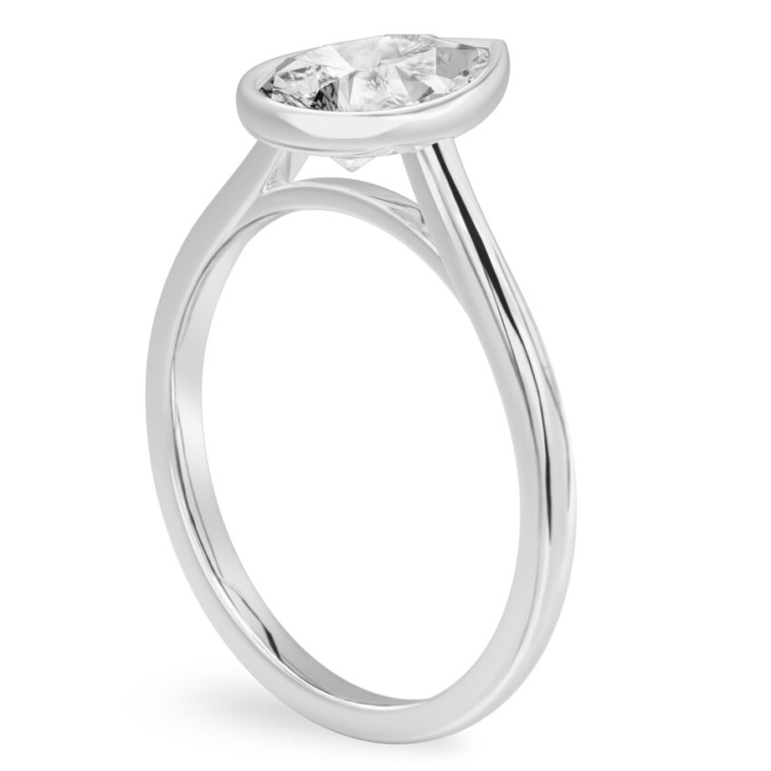 Angle view of pear shape diamond bezel engagement ring in platinum