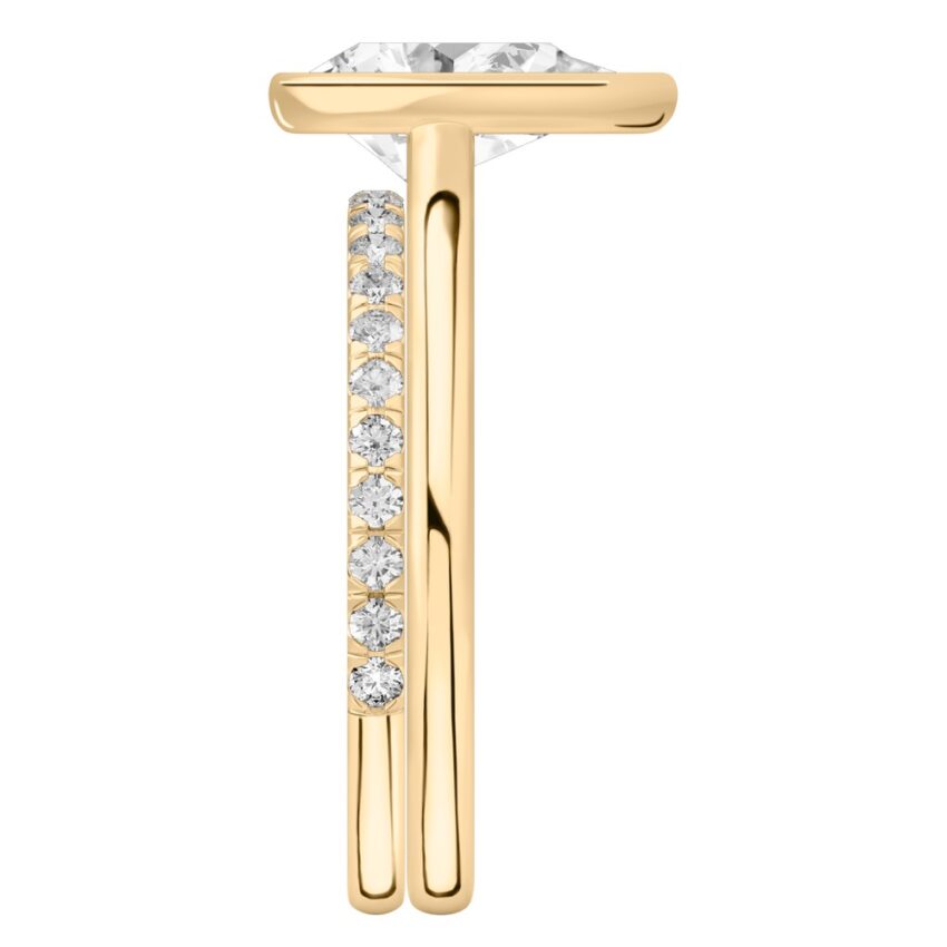 Side view of pear shape diamond bezel engagement ring set yellow gold