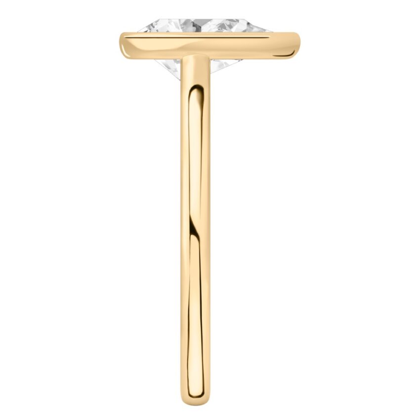 Side view of pear shape diamond bezel engagement ring in yellow gold