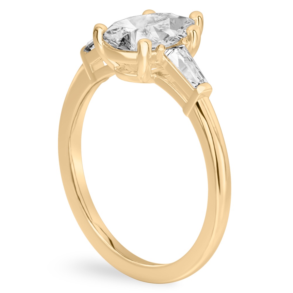 Angle view of pear shape diamond tapered baguette engagement ring in yellow gold