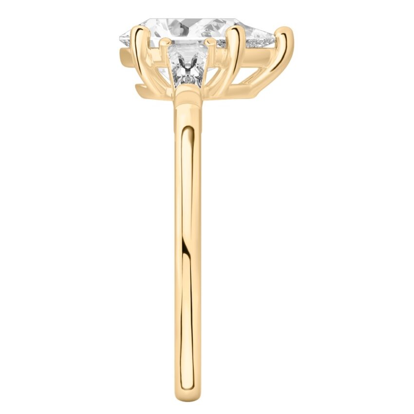 Side view of pear shape diamond tapered baguette engagement ring in yellow gold