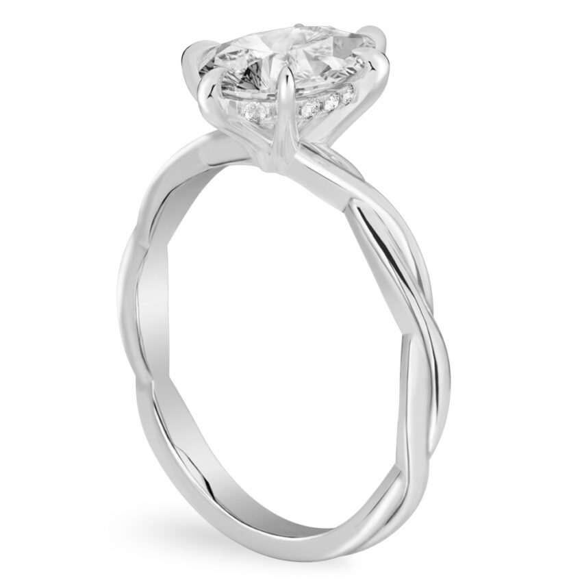 Angle view of pear shape diamond twisted hidden halo engagement ring in platinum