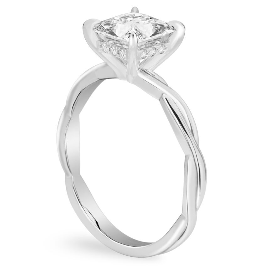Angle view of princess cut diamond twisted hidden halo engagement ring in platinum