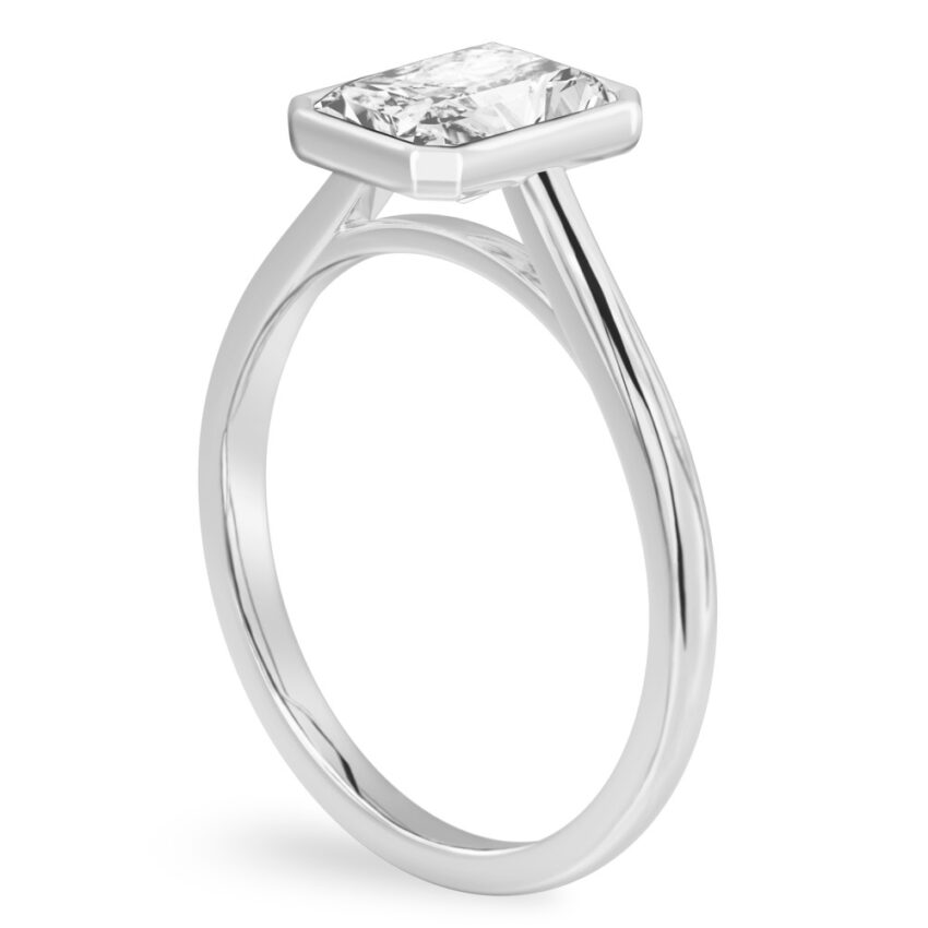 Angle view of radiant cut diamond bezel engagement ring in platinum