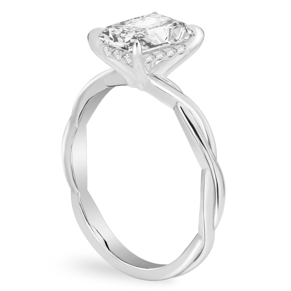 Angle view of radiant cut diamond twisted hidden halo engagement ring in platinum