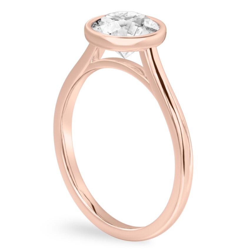 Angle view of round cut diamond bezel engagement ring in rose gold