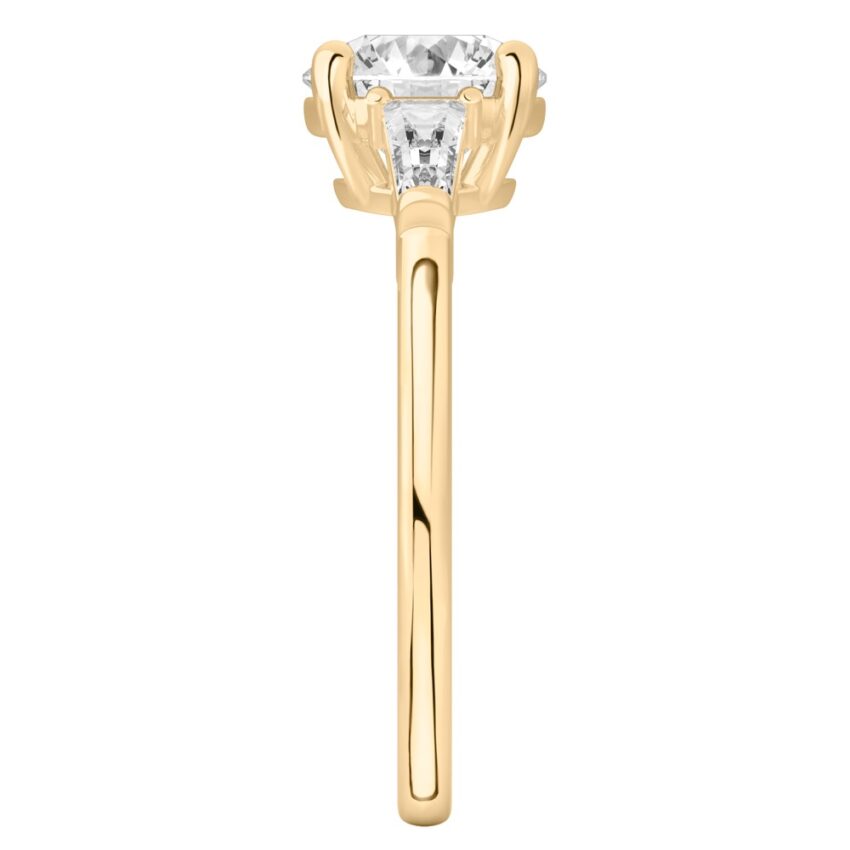 Side view of round cut diamond tapered baguette engagement ring in yellow gold