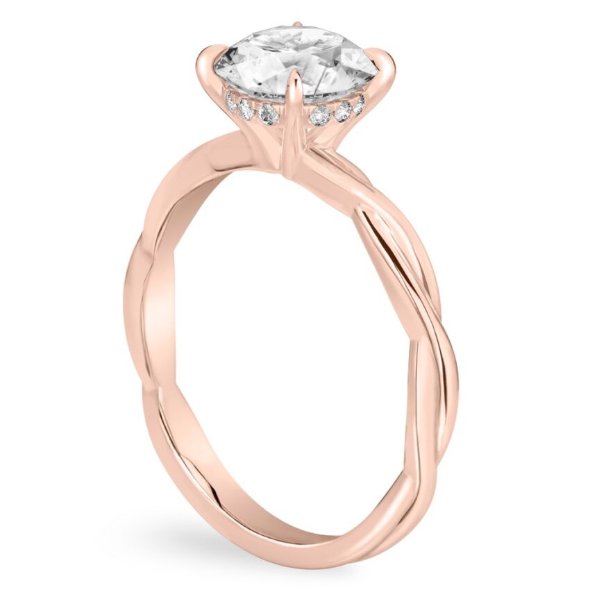 Angle view of round cut diamond twisted hidden halo engagement ring in rose gold