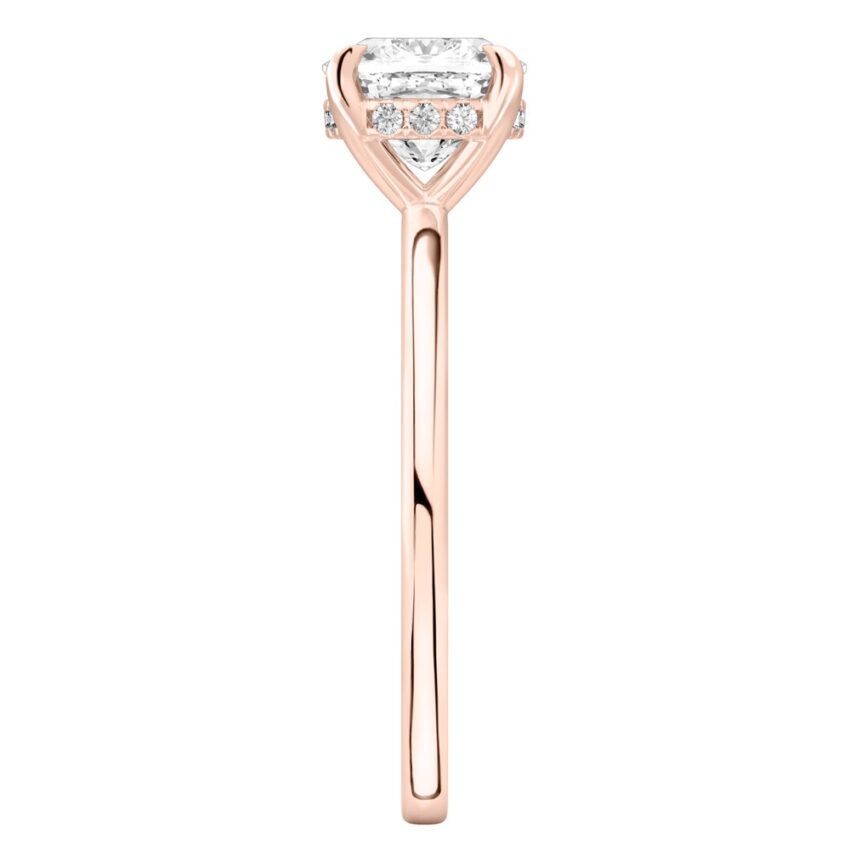 Side view of cushion cut diamond hidden halo engagement ring in rose gold