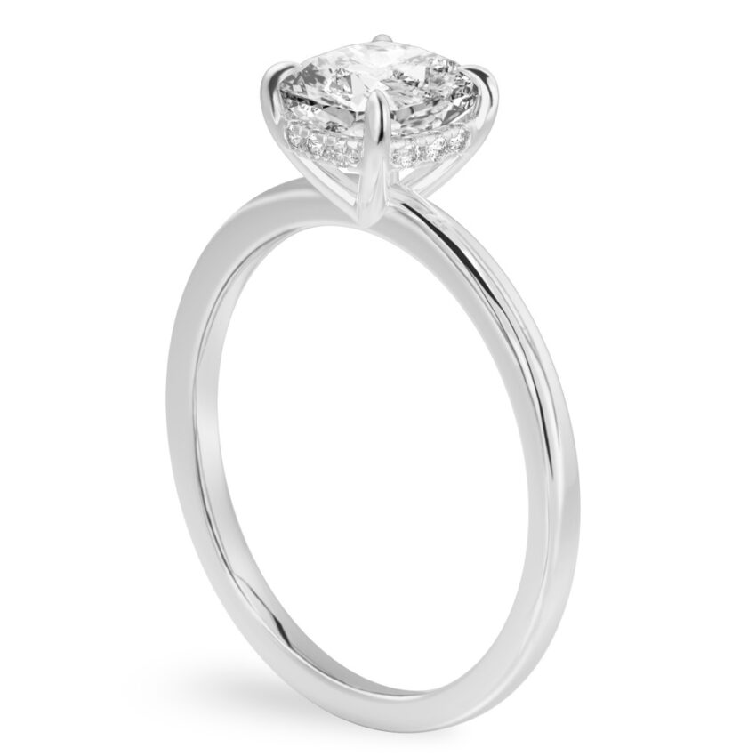Angle view of cushion cut diamond ultra low hidden halo engagement ring in white gold