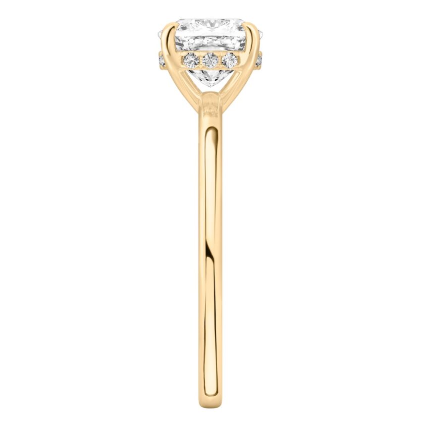Side view of cushion cut diamond ultra low hidden halo engagement ring in yellow gold