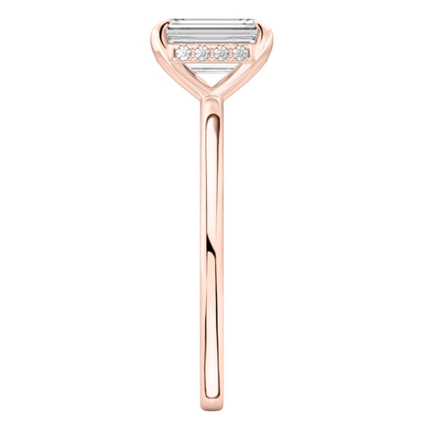 Side view of emerald cut diamond hidden halo engagement ring in rose gold