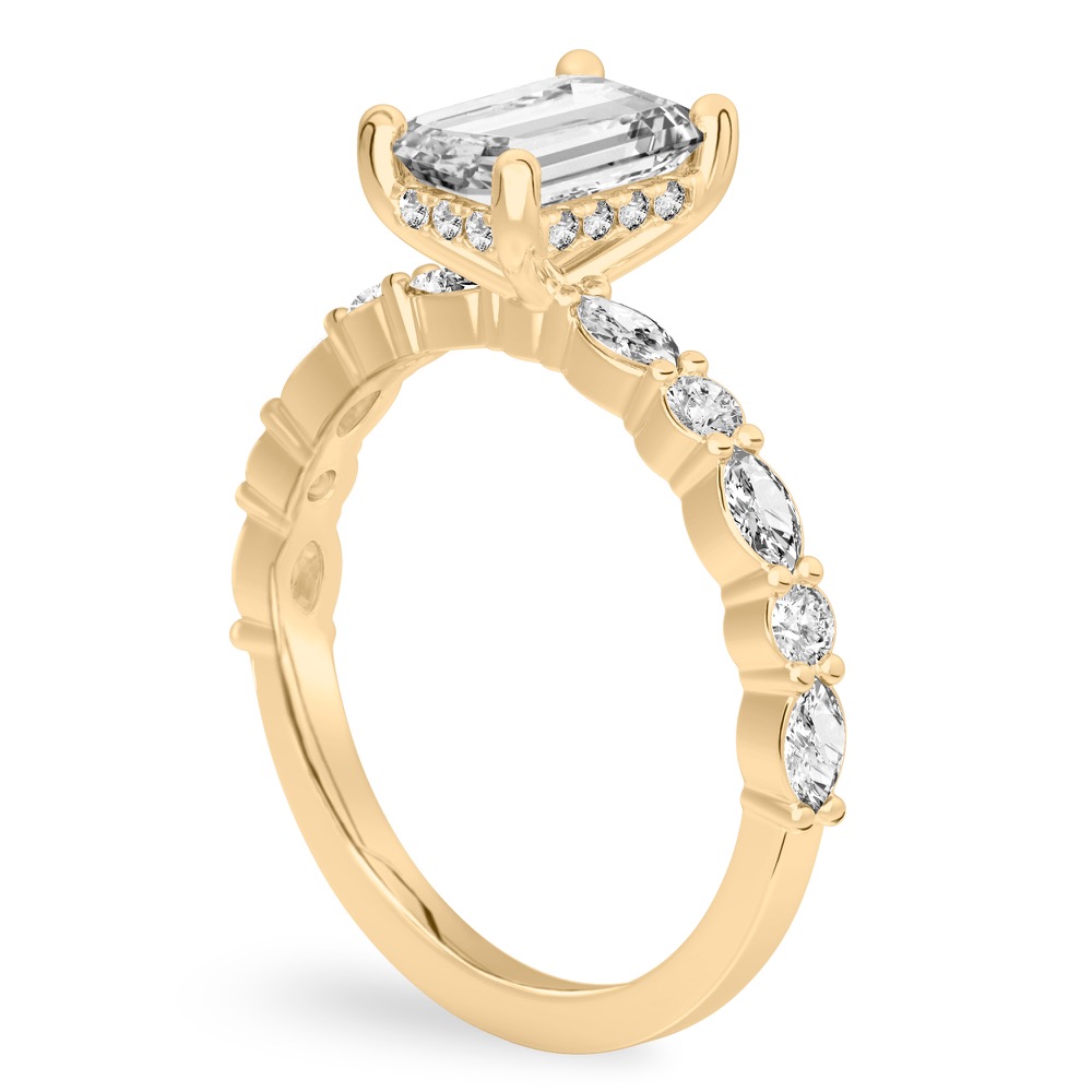 Angle view of emerald cut diamond hidden halo marquise and round diamond ring yellow gold