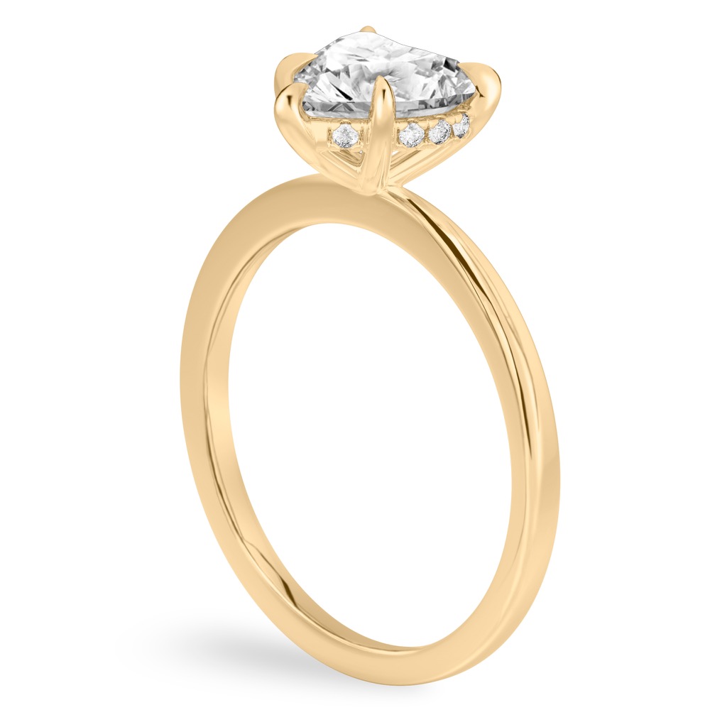 Angle view of heart shape diamond hidden halo engagement ring in yellow gold