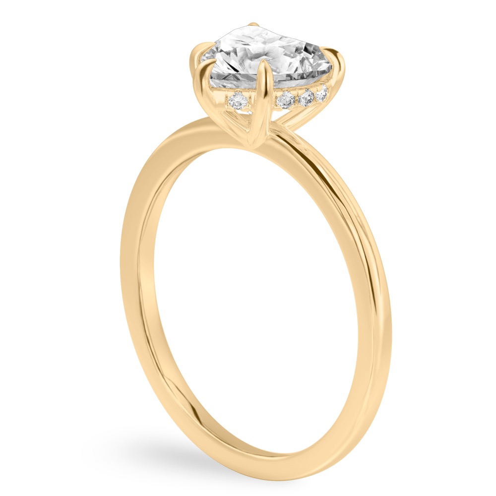 Angle view of heart shape diamond ultra low hidden halo engagement ring in yellow gold