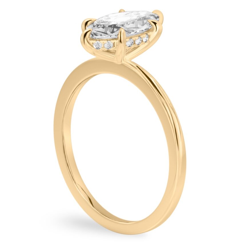 Angle view of marquise cut diamond hidden halo engagement ring in yellow gold