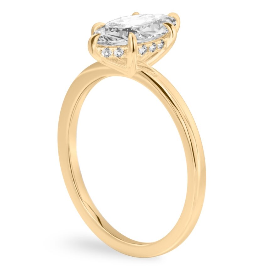 Angle view of marquise cut diamond ultra low hidden halo engagement ring in yellow gold