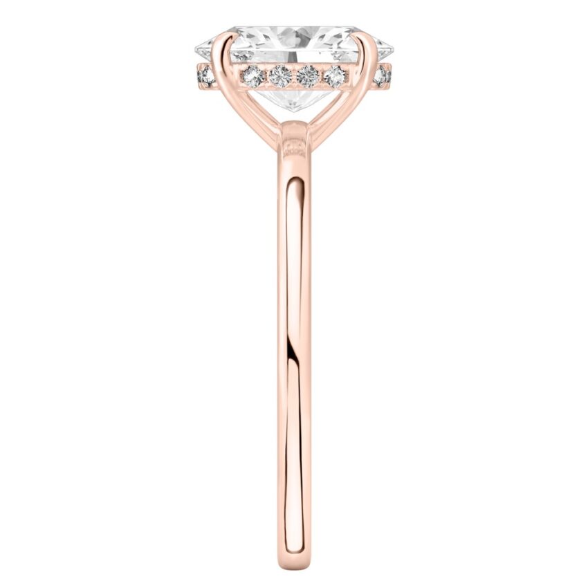 Side view of oval shape diamond ultra low hidden halo engagement ring in rose gold