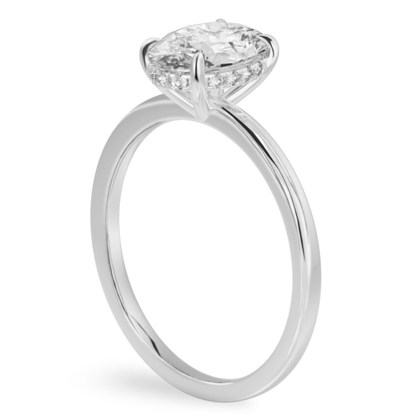 Angle view of oval shape diamond ultra low hidden halo engagement ring in white gold