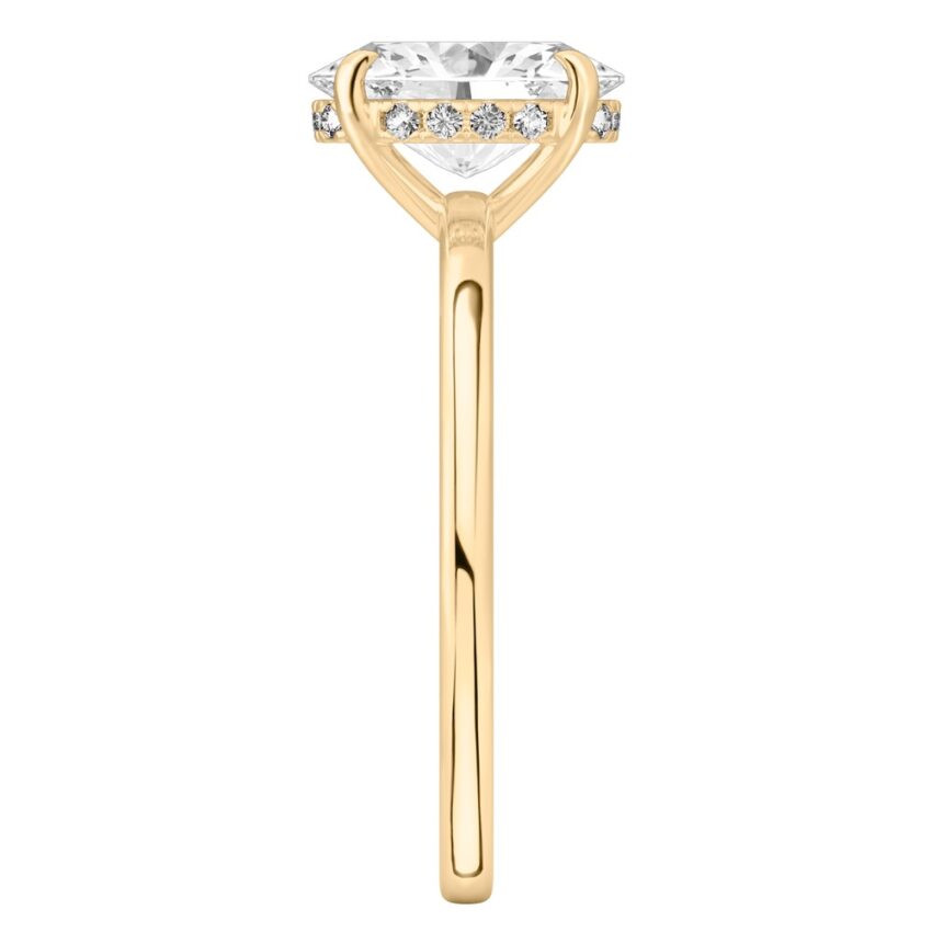Side view of oval shape diamond ultra low hidden halo engagement ring in yellow gold