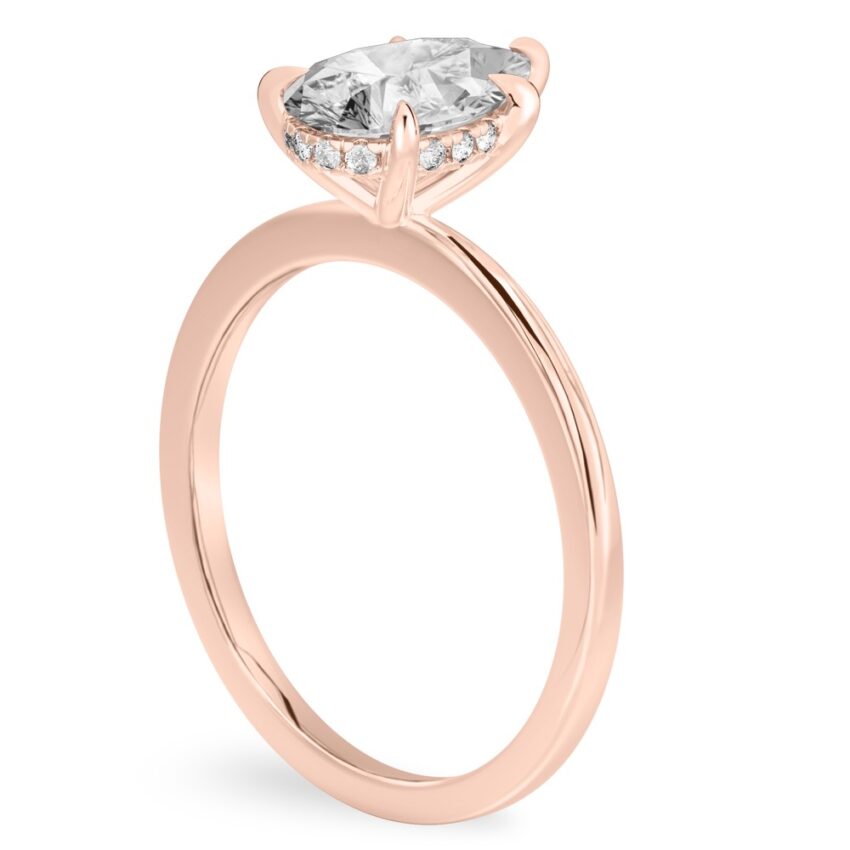 Angle view of pear shape diamond hidden halo engagement ring in rose gold
