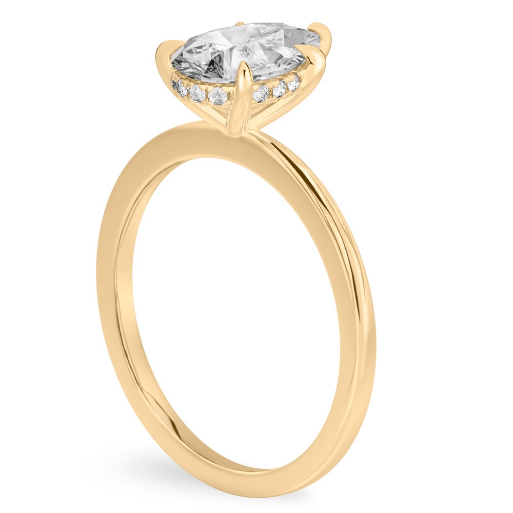 Angle view of pear shape diamond hidden halo engagement ring in yellow gold
