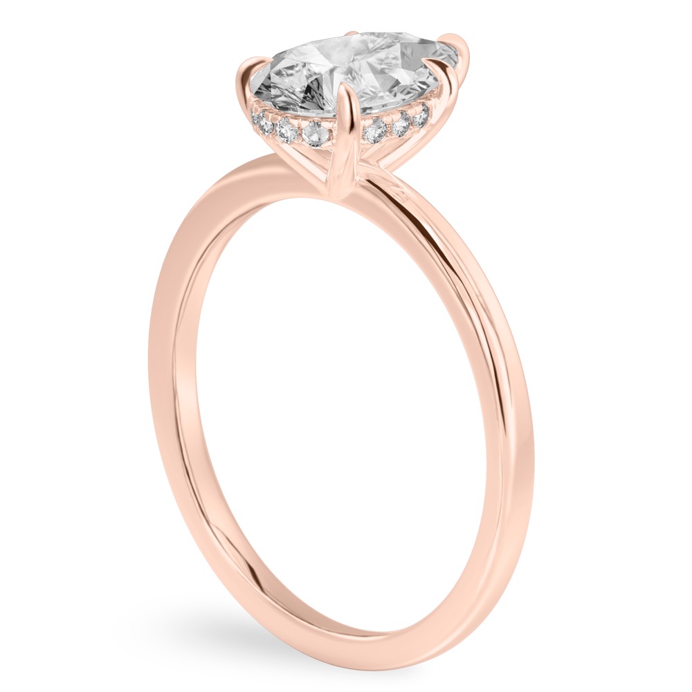 Angle view of pear shape diamond ultra low hidden halo engagement ring in rose gold