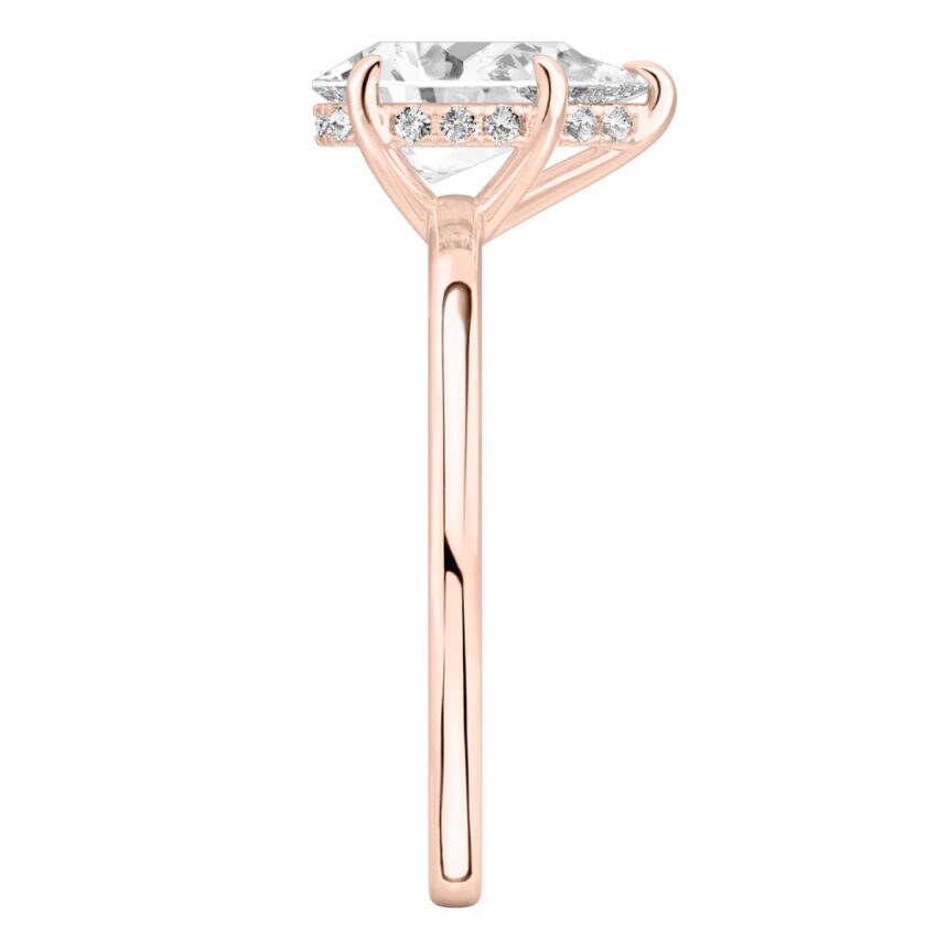 Side view of pear shape diamond ultra low hidden halo engagement ring in rose gold