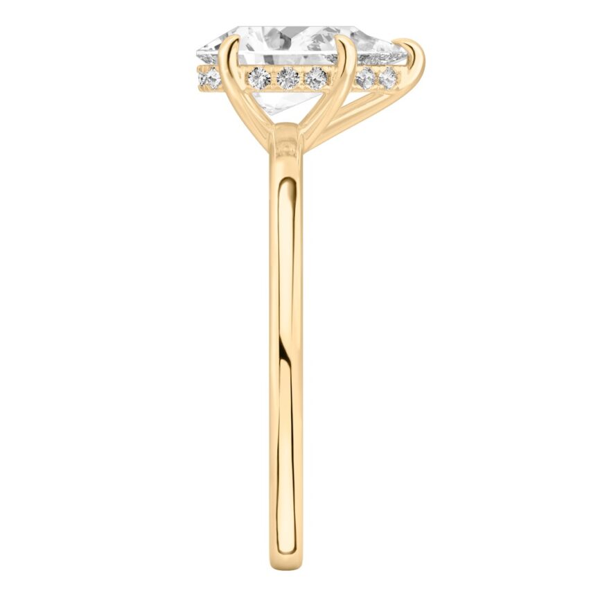 Side view of pear shape diamond ultra low hidden halo engagement ring in yellow gold