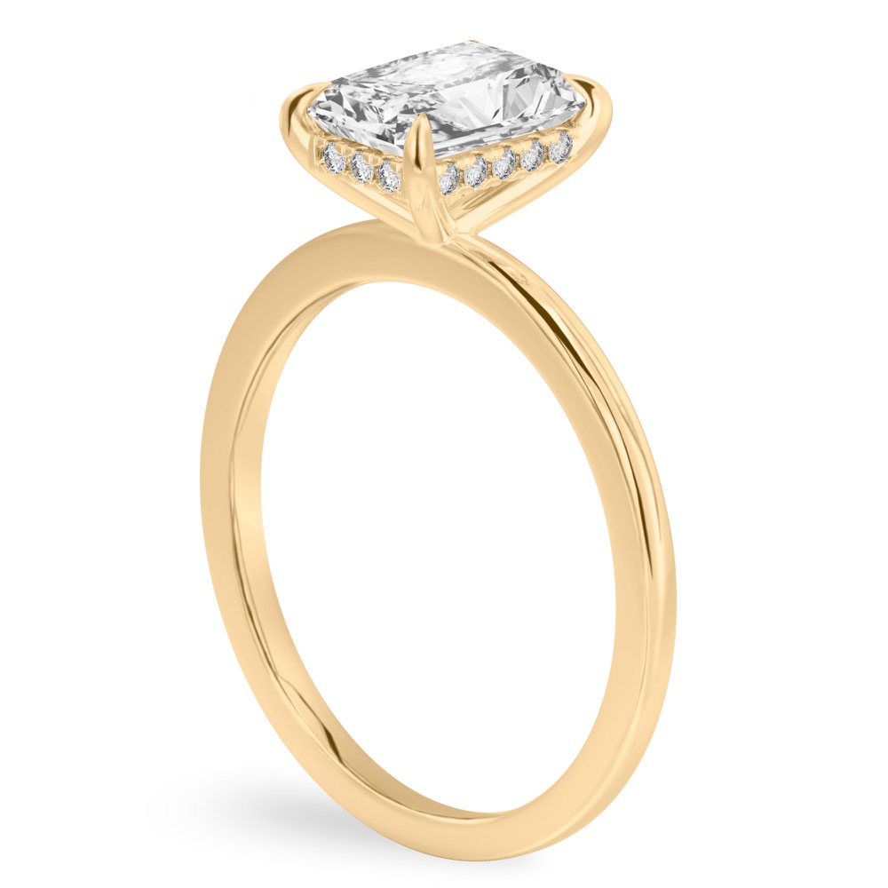 Angle view of radiant cut diamond flush hidden halo engagement ring in yellow gold