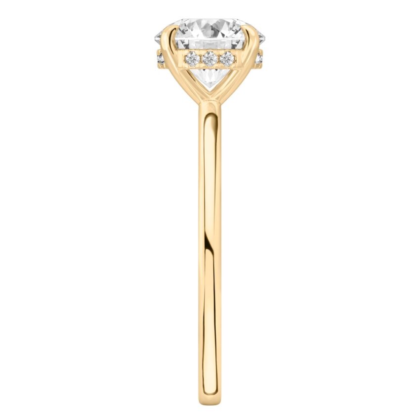 Side view of round cut diamond flush hidden halo engagement ring in yellow gold