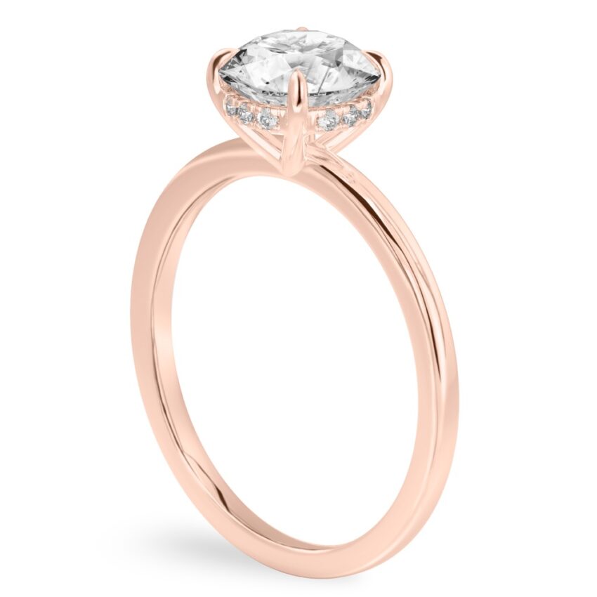 Angle view of round cut diamond ultra low hidden halo engagement ring in rose gold