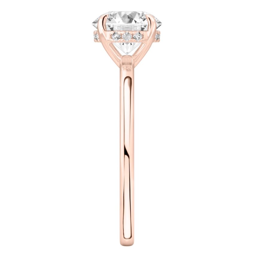 Side view of round cut diamond ultra low hidden halo engagement ring in rose gold