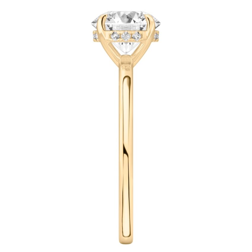 Side view of round cut diamond ultra low hidden halo engagement ring in yellow gold