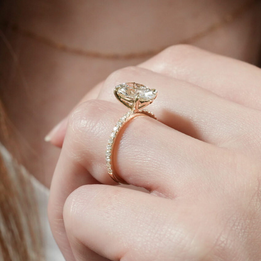 Angle view of delicate pave engagement ring in lifestyle
