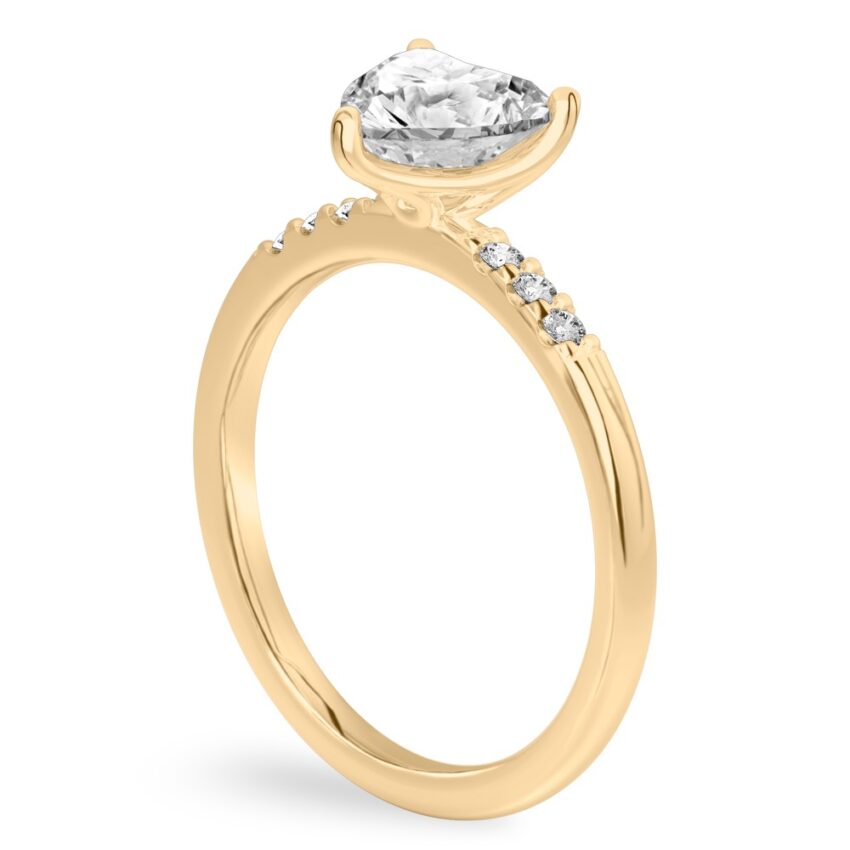 Angle view of heart shape diamond minimalist pave engagement ring in yellow gold